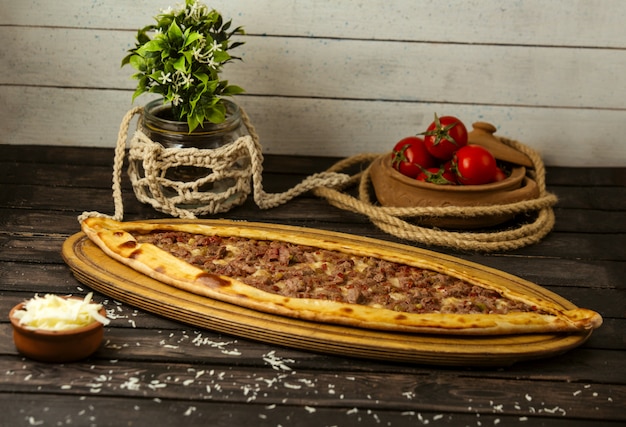 Bezpłatne zdjęcie turecki tradycyjny pide z serem i faszerowanym mięsem na drewnianej desce