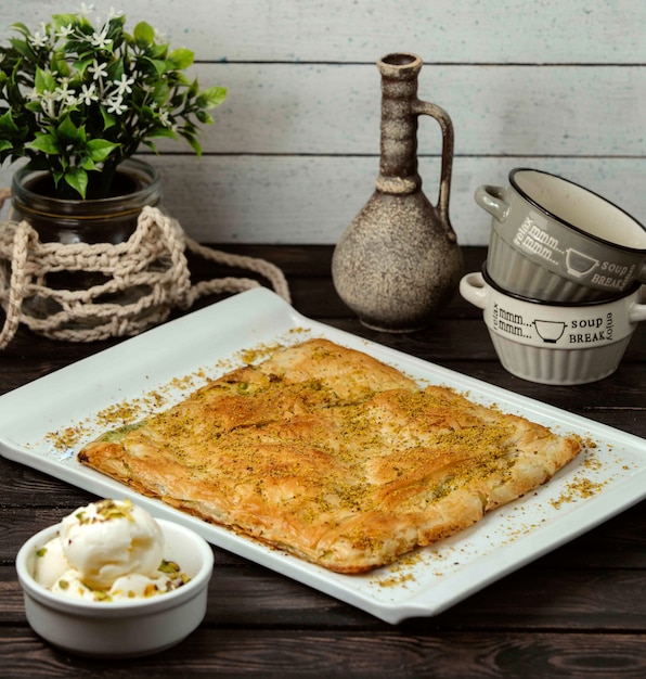 Bezpłatne zdjęcie tureckie słodkie ciasto francuskie z puree pistacjowe na drewnianym stole