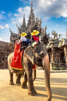 Turyści jeżdżą na słoniach po sanktuarium prawdy w pattaya w tajlandii