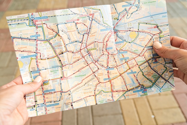 Bezpłatne zdjęcie turysta trzyma mapę na ulicy