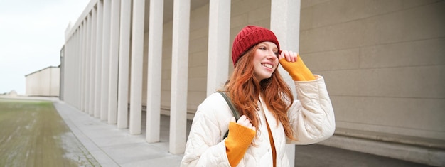 Bezpłatne zdjęcie turystka w czerwonym kapeluszu z plecakiem zwiedza podczas swojej podróży zabytki