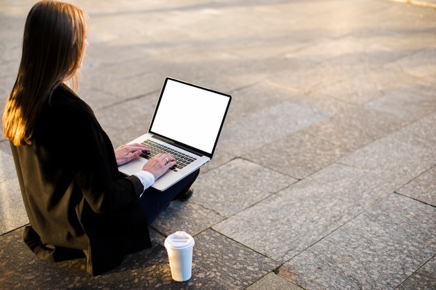 Tylna widok kobieta używa laptop z kopii przestrzenią