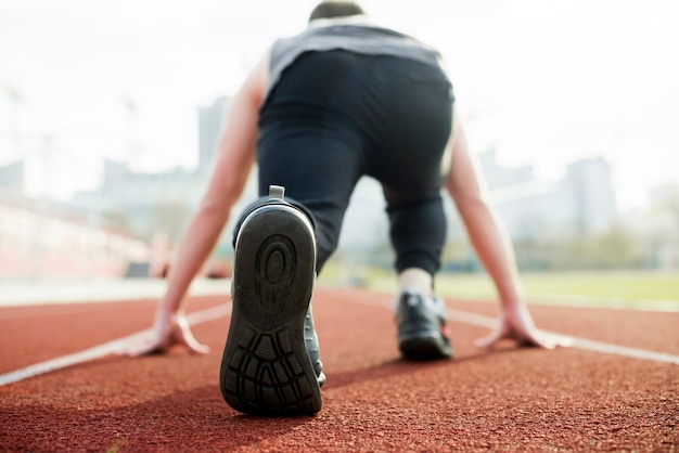 Tylni Widok Męska Atleta Bierze Pozycję Na Czerwonym Biegowym śladzie