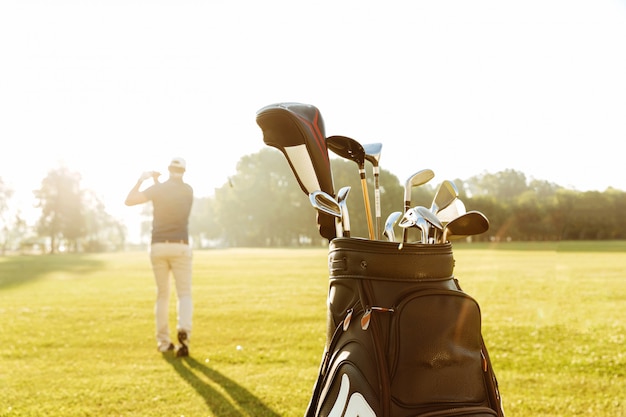 Bezpłatne zdjęcie tylny widok męskiego golfisty kołyszący kij golfowy