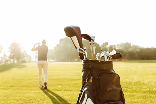 Tylny widok męskiego golfisty kołyszący kij golfowy