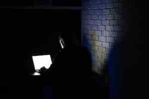 Bezpłatne zdjęcie tylny widok młody skoncentrowany mężczyzna używa laptop