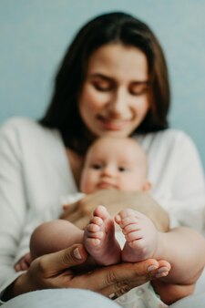 Ubezpieczenie zdrowotne noworodka ubezpieczenie na życie noworodka matka trzymająca w rękach stopy
