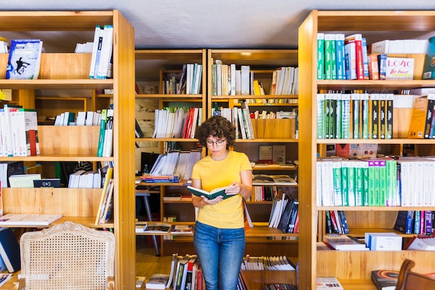 Ucząca się dama stojąca między biblioteczkami