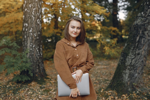 Uczeń pracuje w parku i korzysta z laptopa