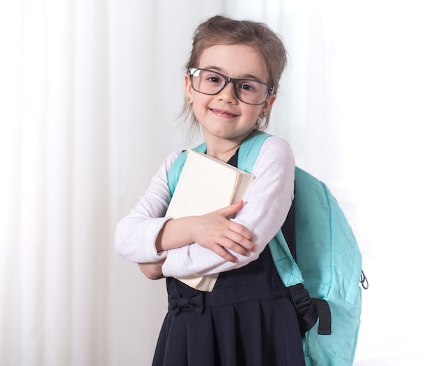 Uczeń szkoły podstawowej z plecakiem i książką