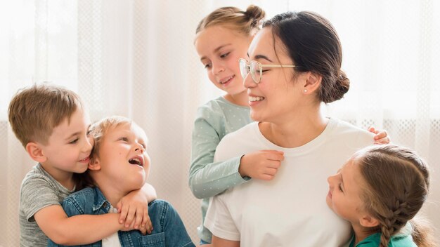 Uczniowie z widokiem z przodu przytulający nauczyciela