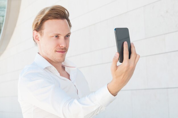 Ufny biznesowy mężczyzna pozuje selfie fotografię i bierze outdoors