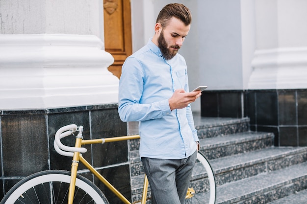 Ufny mężczyzna z smartphone pozycją na schodkach