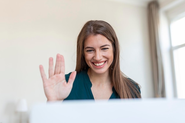 Ujęcie bizneswoman podczas rozmowy wideo siedzącej przy biurku Przycięte zdjęcie atrakcyjnej młodej kobiety korzystającej z laptopa do prowadzenia wideorozmowy w domu