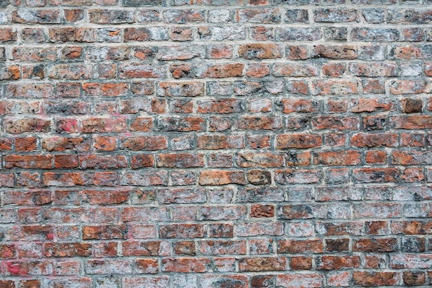 Ujęcie cementowanej ściany z czerwonej i brązowej cegły - idealne do tapet