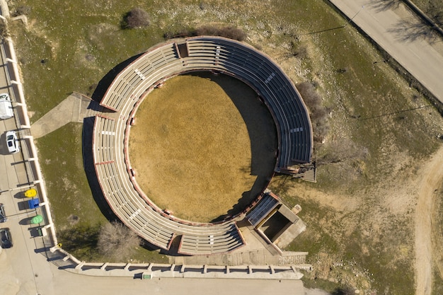 Ujęcie małego kamiennego stadionu na trawiastym podwórku