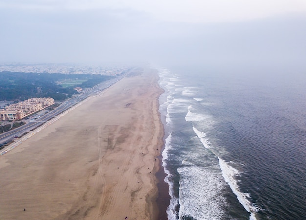 Ujęcie pod dużym kątem fal oceanu spotykających się z brzegiem