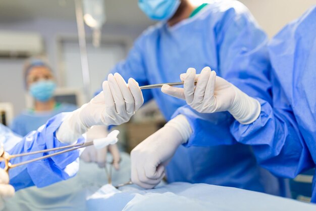 Ujęcie pod niskim kątem w sali operacyjnej Asystent wręcza chirurgom instrumenty podczas operacji Chirurdzy wykonują operację Profesjonalni lekarze przeprowadzający operacje