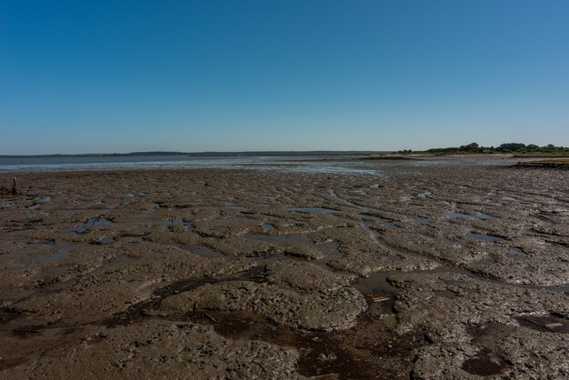 Ujęcie suchej, piaszczystej plaży w Cais Palafítico da Carrasqueira, Portugalia podczas odpływu