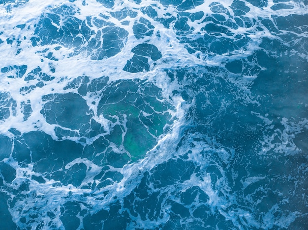 Ujęcie z lotu ptaka falującego błękitnego morza — idealne na urządzenia mobilne
