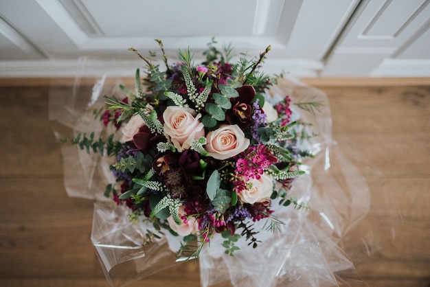 Ujęcie zbliżenie narzutów bukiet kwiatów ślubnych na drewnianej podłodze