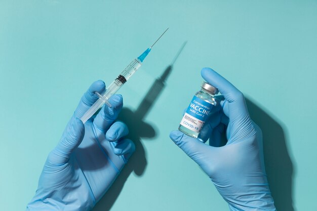 Układ koronawirusa z butelką ze szczepionką i strzykawką