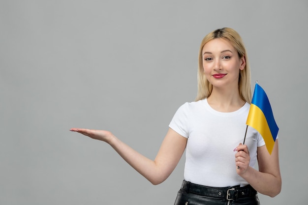 Bezpłatne zdjęcie ukraina rosyjski konflikt blondynka ładna dziewczyna z czerwoną szminką i ukraińską flagą machającą rękami