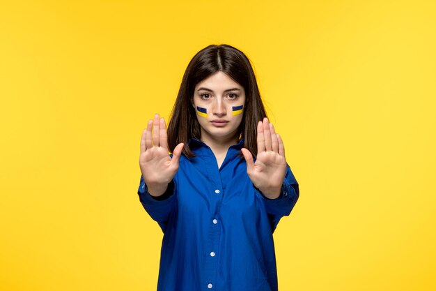Ukraina rosyjski konflikt urocza młoda dziewczyna w niebieskiej koszuli na żółtym tle podnosząca obie ręce stop