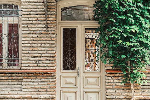 Ulice starego Tbilisi pomysł na pocztówkę lub reklamę Drzwi i ściana domu oplata bluszcz
