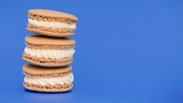 Bezpłatne zdjęcie ułożone macaroons na niebieskim tle