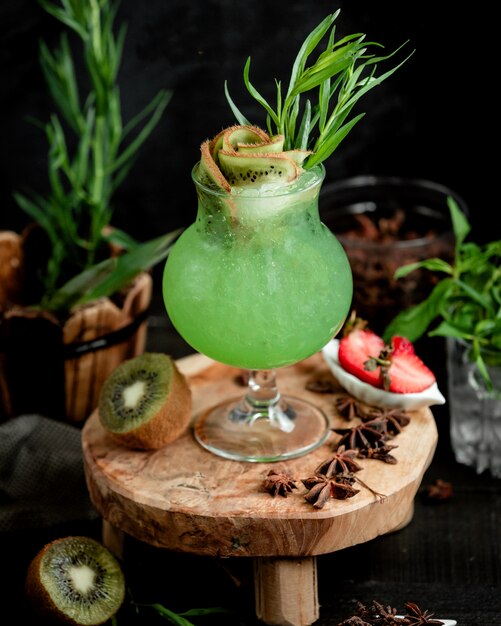 Unikalna szklanka koktajlu kiwi ozdobiona plastrami kiwi i estragonem