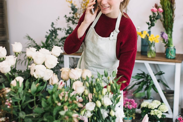 Bezpłatne zdjęcie upraw kwiaciarni mówienie na smartphone