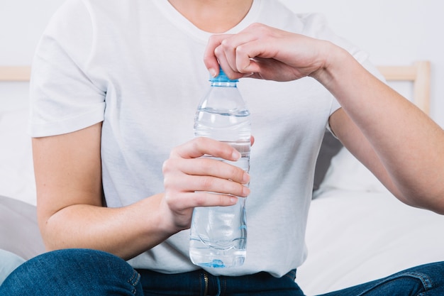Uprawy kobieta otwierając butelkę wody