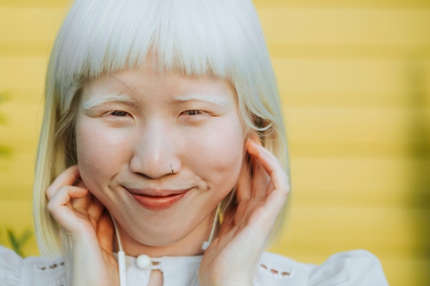 Urocza dziewczyna albinos słuchająca ulubionej muzyki przez słuchawki