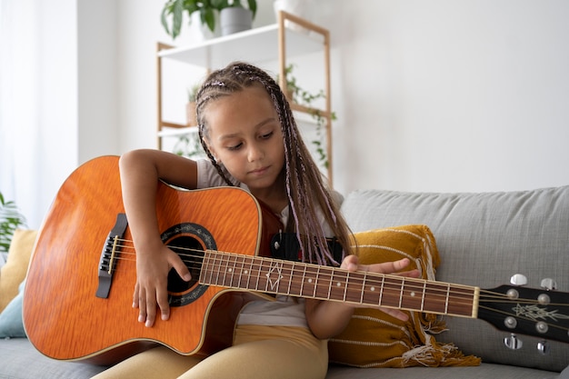 Urocza dziewczyna grająca na gitarze w domu
