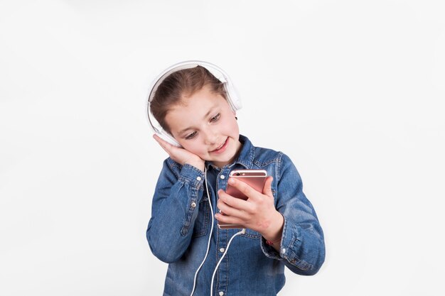 Urocza dziewczyna w słuchawkach przeglądania smarthone