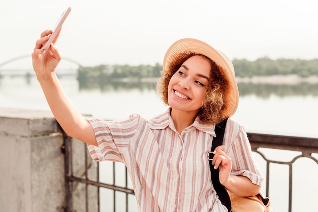 Bezpłatne zdjęcie urocza kobieta uśmiechając się do selfie