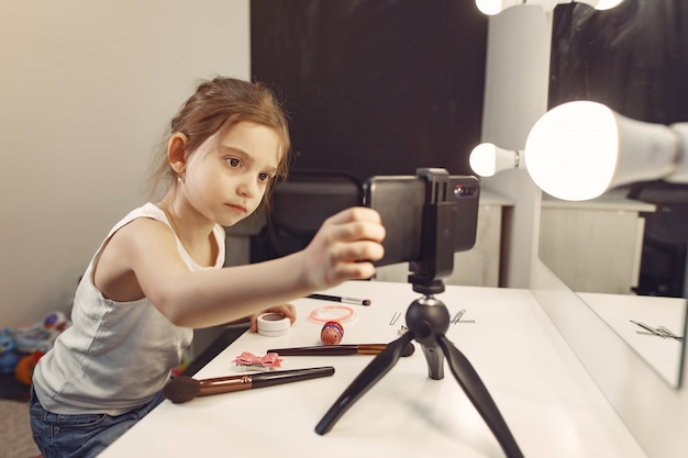 Urocza mała blogerka z kosmetykami nagrywająca wideo w domu