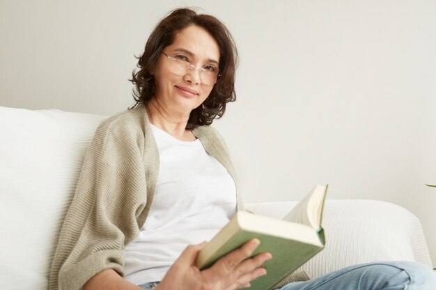 Urocza pani w średnim wieku, która lubi spędzać czas w domu i czytać
