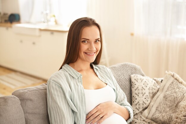 Urocza śliczna młoda kobieta w ciąży pozowanie