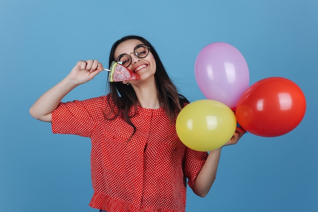 Uroczy młoda kobieta brunetka stoi z lollipop i balony