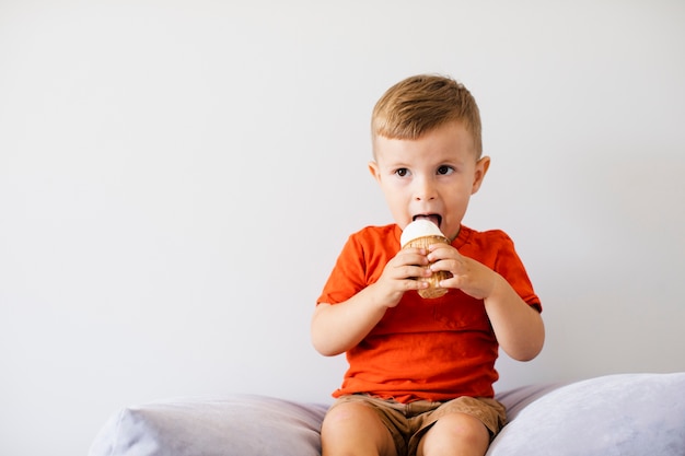 Bezpłatne zdjęcie uroczy młody dzieciak je lody