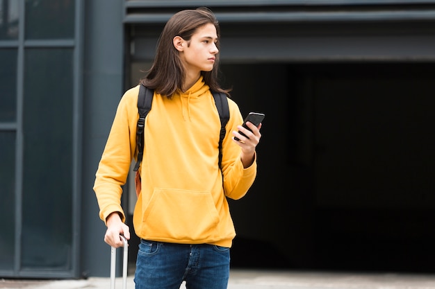 Uroczy Młody Podróżnik Trzyma Jego Telefon