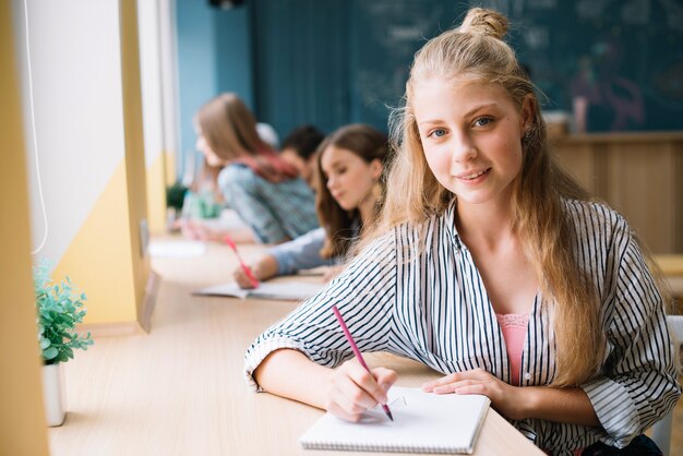 Uroczy student pisania w notatniku