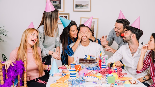Bezpłatne zdjęcie urodzinowy pojęcie z przyjaciółmi przy stołem