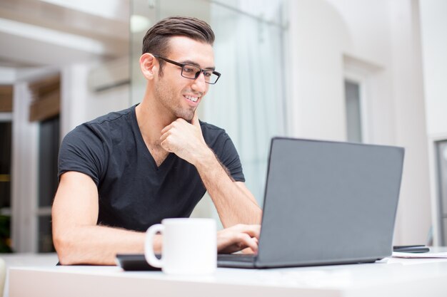 Uśmiecha Się Młodych Przystojny Mężczyzna Pracuje na Laptopa