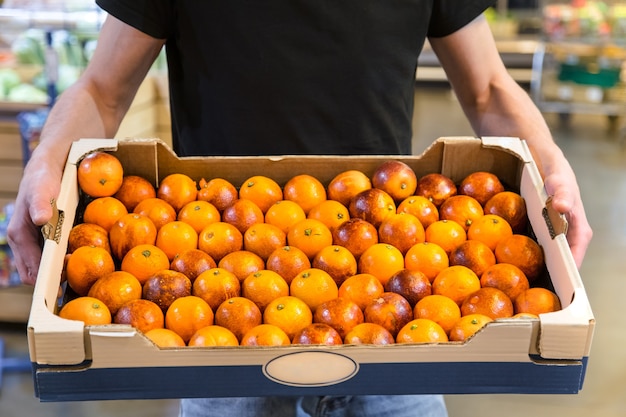 Uśmiechnięci klienci kupujący sycylijskie pomarańcze w sekcji spożywczej