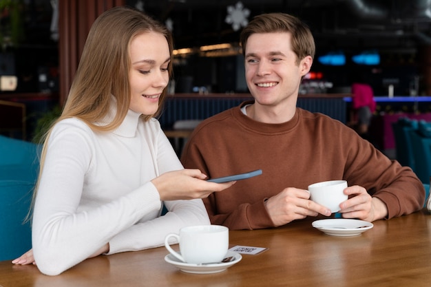 Bezpłatne zdjęcie uśmiechnięci ludzie w restauracji ze średnim strzałem?