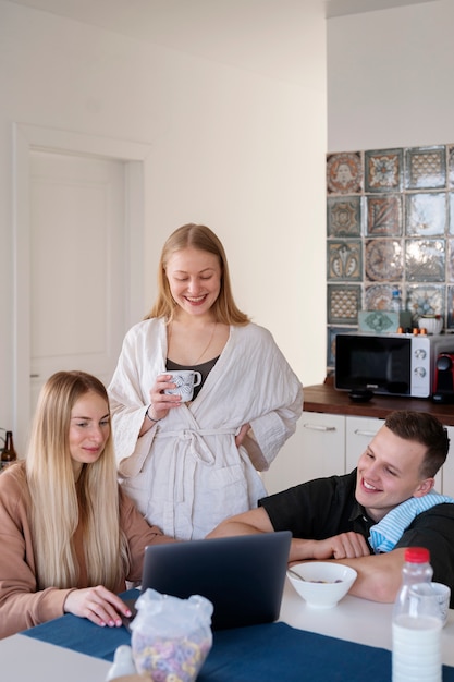 Uśmiechnięci ludzie ze średnim strzałem patrzący na laptopa