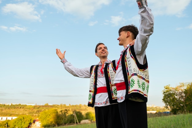 Uśmiechnięci mężczyźni o niskim kącie z tradycyjnymi ubraniami